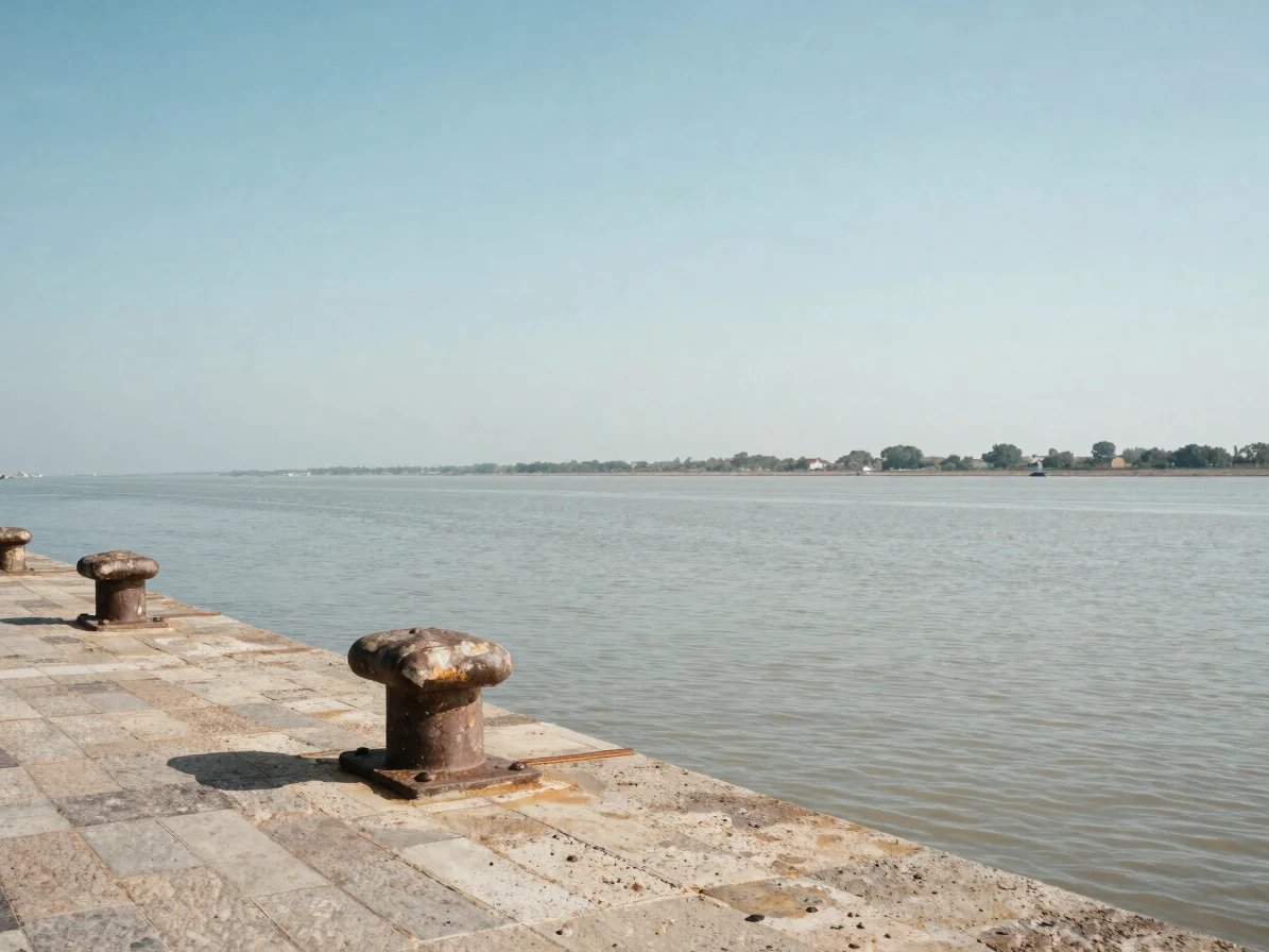 Old stone wharf on the Gironde estuary with weathered bollards an